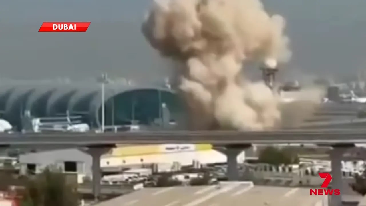Close-up of a smoke and dust plume at Dubai International Airport next to the terminal.