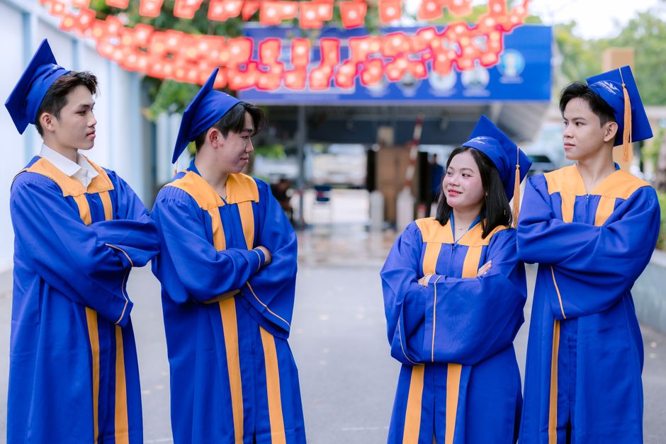 Joyful group of graduates in blue gowns celebrating outdoors. Perfect for education and achievement themes.