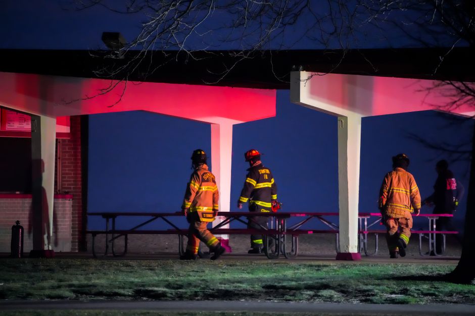 Firefighters at a park during nighttime lighting. Emergency response scene.