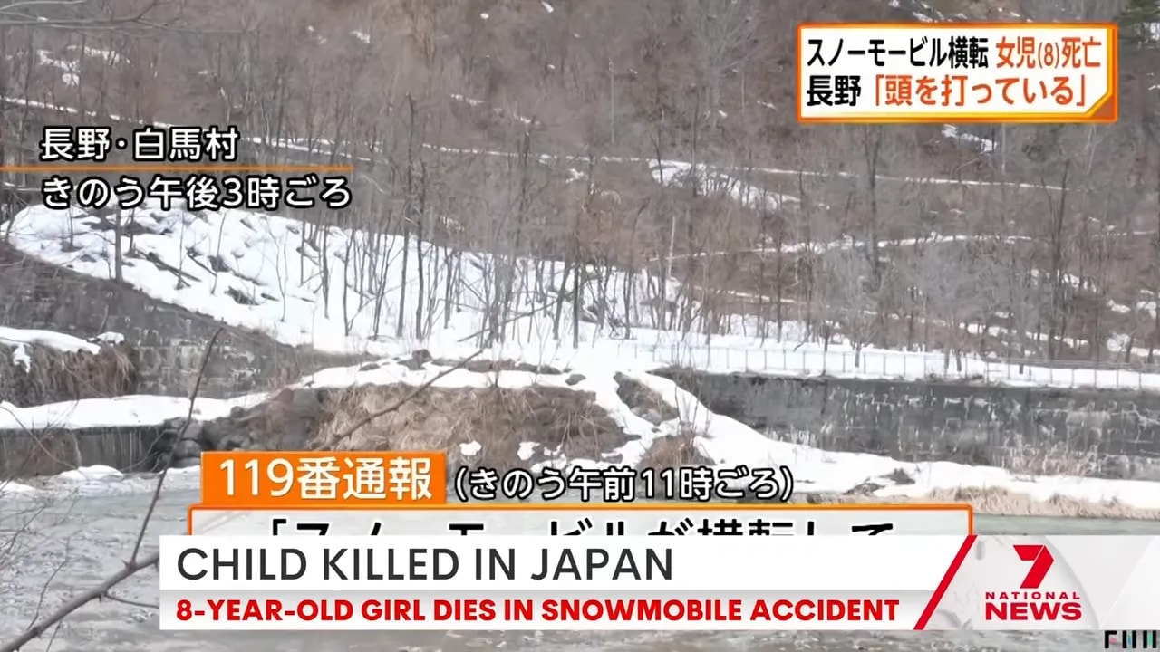 Snow-covered riverside slope near Hakuba Village with Japanese news captions and on-screen graphics.