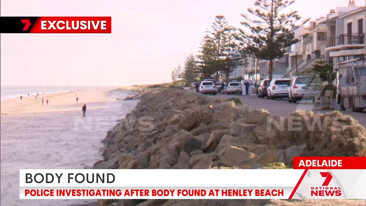 Henley Beach shoreline and nearby apartments with police investigation at dawn