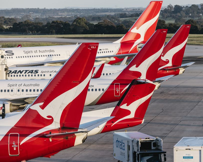 Multiple Qantas airplanes parked at Melbourne Airport, Australia, showcasing aviation and travel themes.