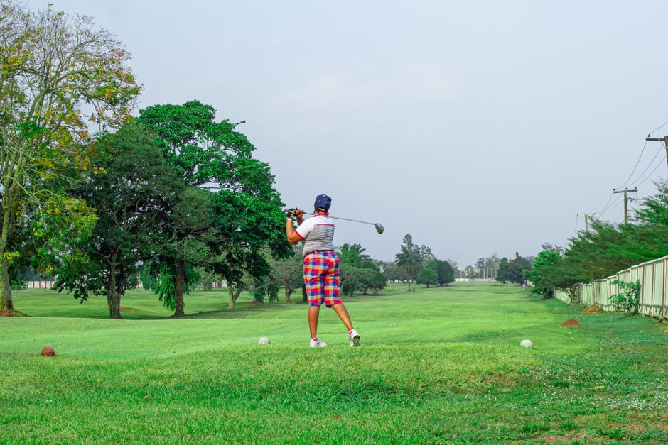 Person playing golf on a lush green course under a clear sky in Johannesburg. Vibrant and leisure scene.