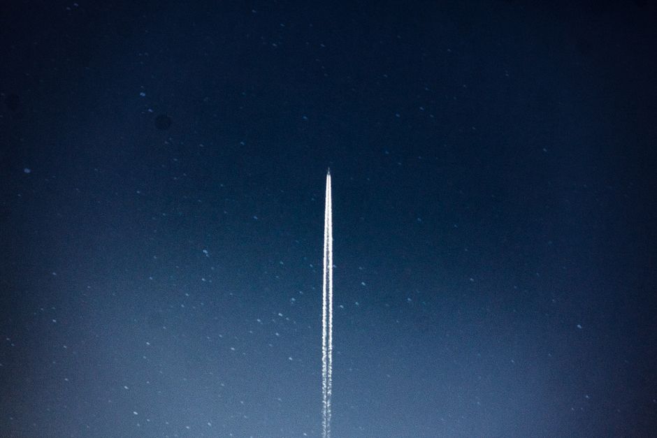 A rocket streaks through a starry night, leaving a trail in outer space.