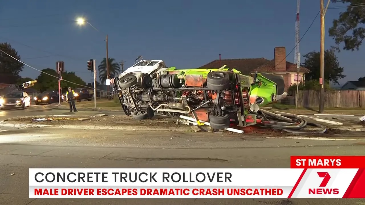 Concrete pump truck rollover in St Marys with damaged green truck and emergency scene