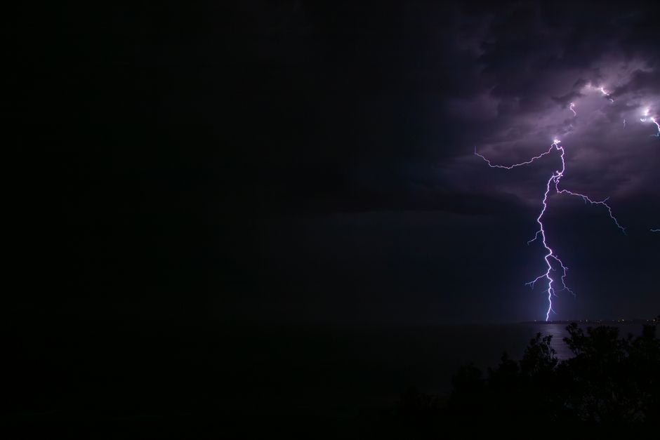 Striking lightning bolt captured over Culburra Beach, Australia during a nighttime storm.