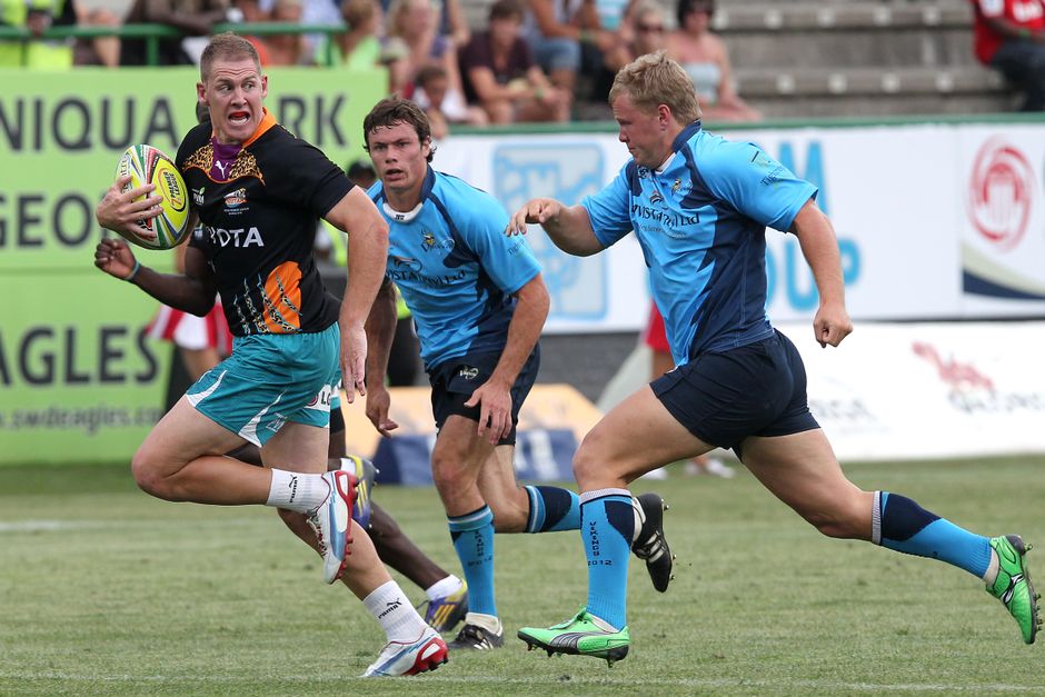 Dramatic moment captured during a competitive rugby match with players in action on the field.